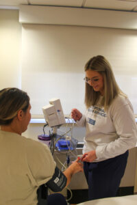 Kamryn Gittings, CNA, takes a patient's vitals