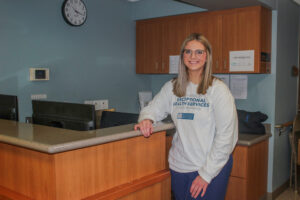 Kamryn Gittings, CNA, stands at nurse's station